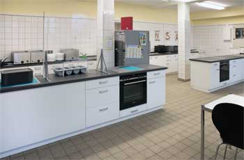 Schulküche und Ausgabeküche mit zwei Kücheninseln.